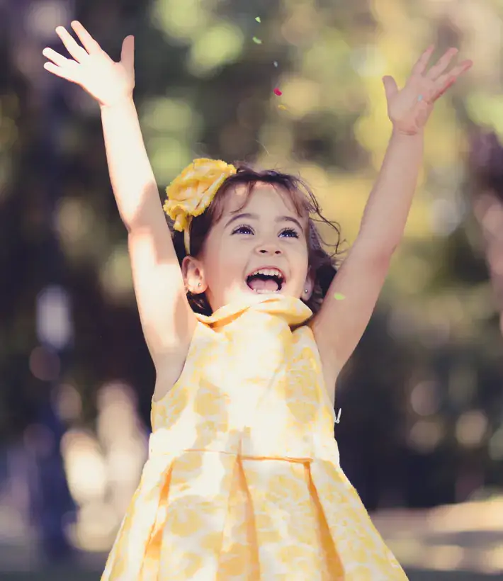 Niña feliz lanzando confeti